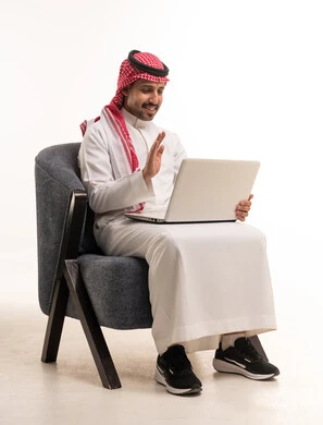 رجل سعودي يستخدم اللابتوب لمكالمة فيديو في الاستوديو