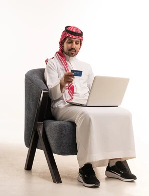 Saudi Man Using Laptop and Credit Card for Online Shopping