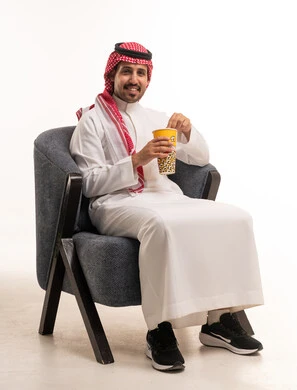 Saudi Man in Traditional Dress Eating Popcorn