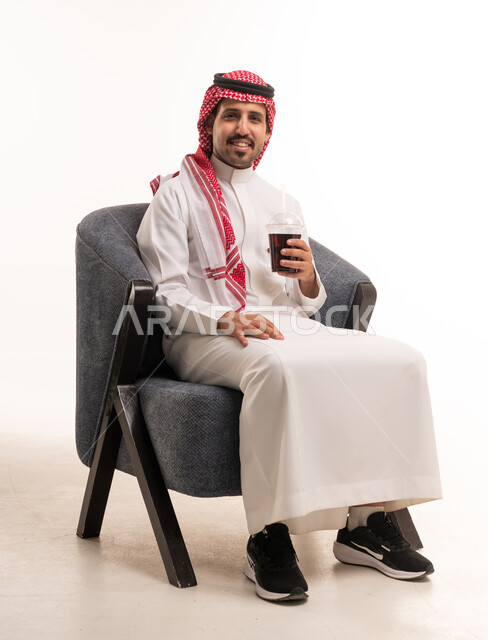Saudi Man in Traditional Thobe Sitting with Cold Drink