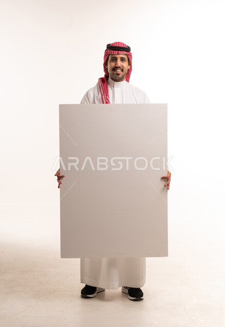 Saudi Man in Traditional Thobe Holding Blank Signboard
