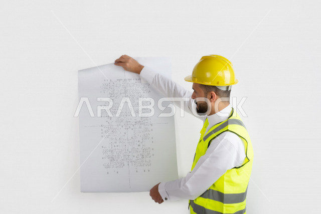 بورتريه رجل مهندس سعودي عربي ،  مهندس ماهر محترف في المخططات ، رجل مهندس خليجي ، خلفية بيضاء