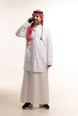 طبيب سعودي بالمعطف الطبي يتحدث عبر الهاتف