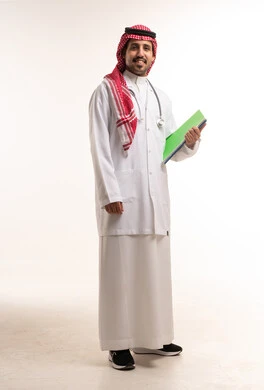 طبيب سعودي يرتدي معطف المختبر ويحمل ملفاً طبياً في استوديو