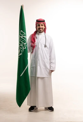 طبيب سعودي يحمل العلم الوطني السعودي في الاستوديو