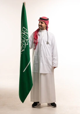 طبيب سعودي يحمل العلم الوطني للمملكة العربية السعودية