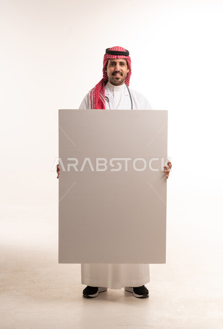 طبيب سعودي يمسك لوحة بيضاء فارغة للإعلان
