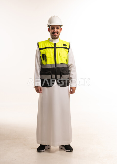 مهندس سعودي يرتدي سترة السلامة وخوذة العمل
