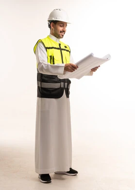 مهندس سعودي مع مخططات هندسية ومعدات السلامة