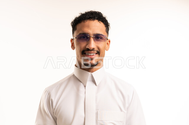 شاب سعودي مبتسم بالثوب التقليدي خلفية بيضاء