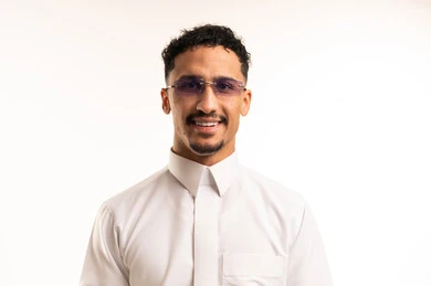 شاب سعودي مبتسم بالثوب التقليدي خلفية بيضاء