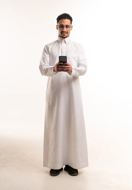 Saudi Man in Traditional Thobe Using Smartphone