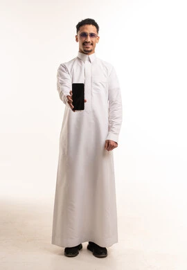 رجل سعودي بالثوب الأبيض يمسك هاتف ذكي في استوديو