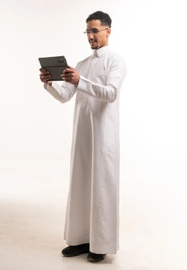 رجل سعودي بالثوب يستخدم جهاز لوحي في الاستوديو