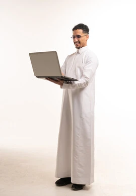 Saudi Man in White Thobe Using Laptop in Studio