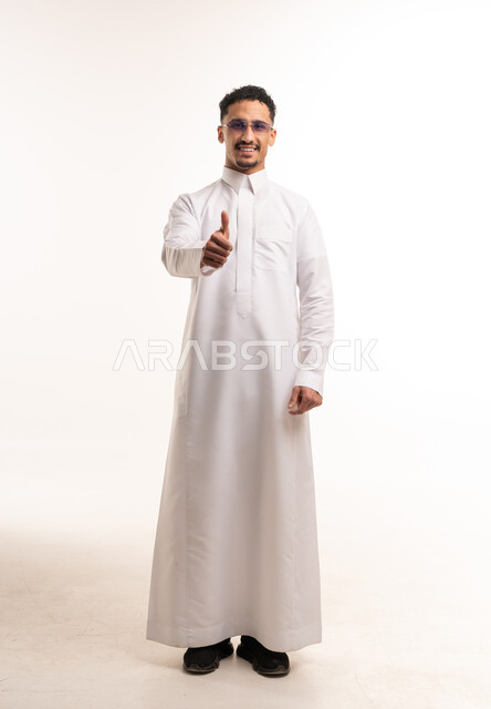 رجل سعودي بالثوب الأبيض يرفع إبهامه للموافقة