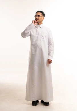 رجل سعودي يرتدي الثوب الأبيض بوضعية التفكير في استوديو