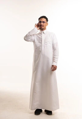 رجل سعودي يرتدي الثوب الأبيض التقليدي يستمع في الاستوديو