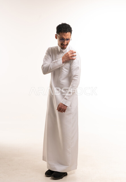 رجل سعودي بالثوب الأبيض يحك كتفه بخلفية بيضاء
