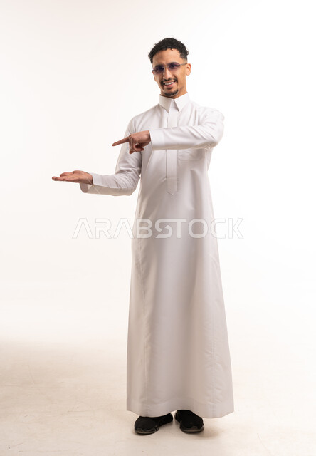 رجل سعودي بالثوب الأبيض يشير في استوديو