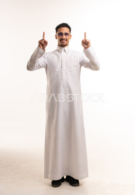 رجل سعودي بالثوب التقليدي يشير للأعلى في الاستوديو