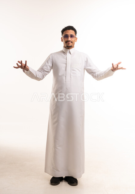 رجل سعودي يرتدي الثوب الأبيض التقليدي ويشير بيده