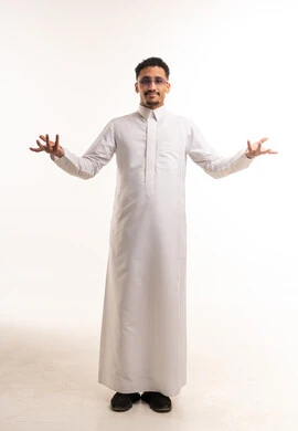 رجل سعودي يرتدي الثوب الأبيض التقليدي ويشير بيده