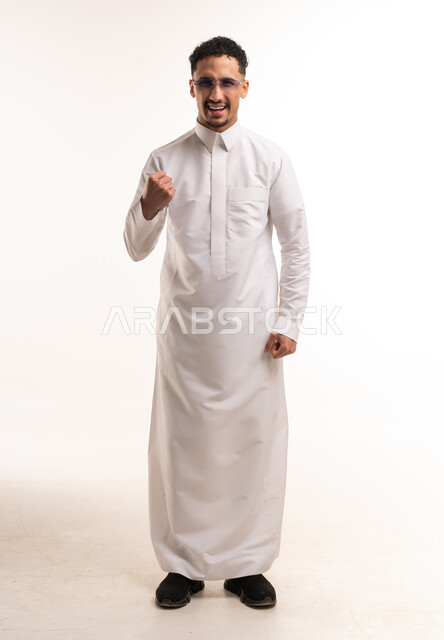 رجل سعودي بالثوب الأبيض يقوم بإيماءة النصر