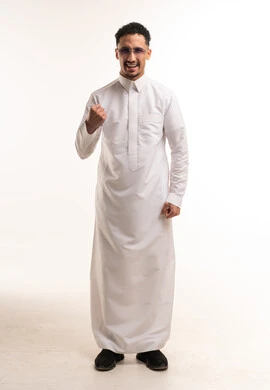 رجل سعودي بالثوب الأبيض يقوم بإيماءة النصر