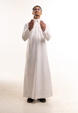 رجل سعودي بالثوب الأبيض يرفع يديه للدعاء