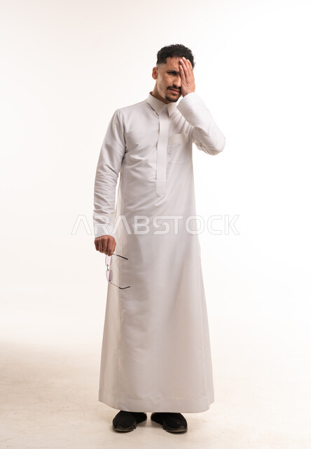 رجل سعودي بالثوب الأبيض يعبر عن الإرهاق