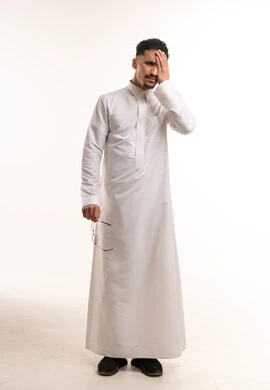 رجل سعودي بالثوب الأبيض يعبر عن الإرهاق