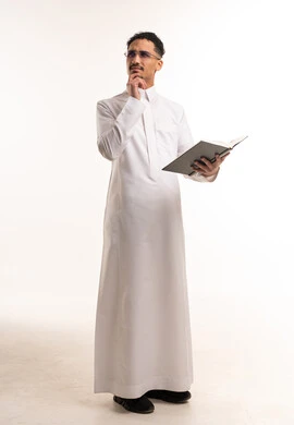 Saudi Man in White Thobe Thinking and Holding Book