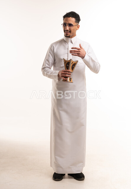 رجل سعودي بالثوب الأبيض يحمل مبخرة تقليدية في الاستوديو