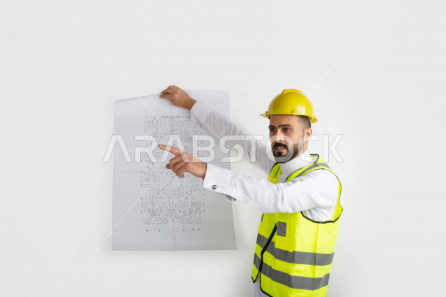 بورتريه رجل مهندس سعودي عربي ،  مهندس ماهر محترف في المخططات ، رجل مهندس خليجي ، خلفية بيضاء