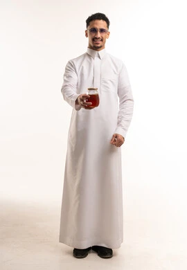 رجل سعودي بالثوب التقليدي يحمل جرة عسل