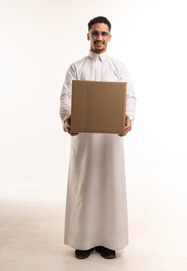 رجل سعودي بالثوب يحمل صندوق كرتوني في الاستوديو