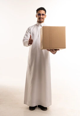 رجل سعودي بالثوب الأبيض يحمل صندوق شحن في استوديو