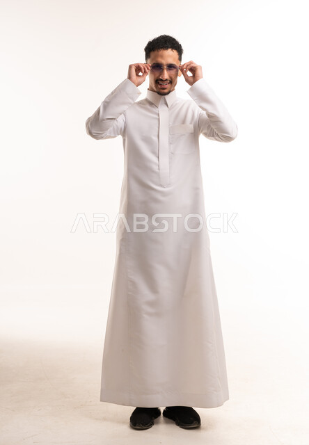رجل سعودي بالثوب الأبيض التقليدي يرتدي نظارة