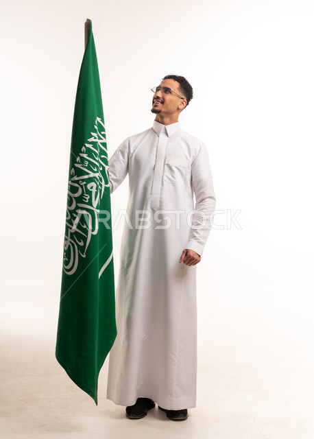 Saudi Man in Thobe Holding National Flag