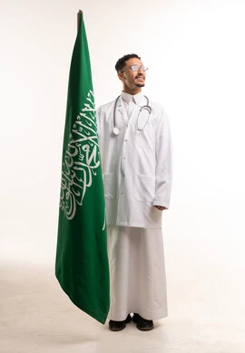 طبيب سعودي مع علم المملكة والسماعة الطبية