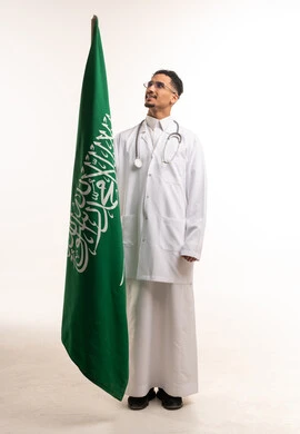 طبيب سعودي مع العلم الوطني في الاستوديو