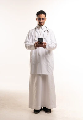 طبيب سعودي بالمعطف المختبري يستخدم الهاتف الذكي