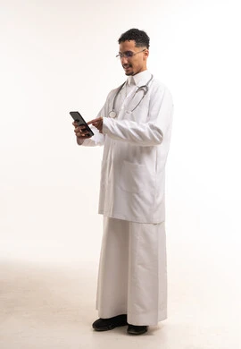 Saudi Male Doctor in Thobe Using Smartphone