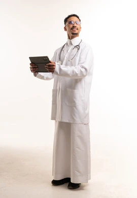 طبيب سعودي بالثوب التقليدي يحمل جهاز لوحي