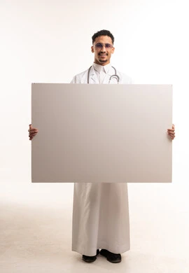 طبيب سعودي يحمل لوحة بيضاء فارغة للإعلان