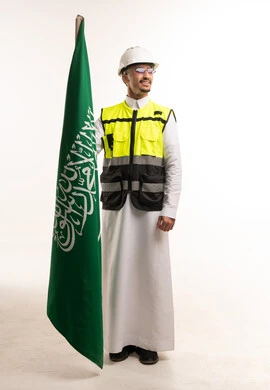 Saudi Engineer Holding National Flag in Safety Gear