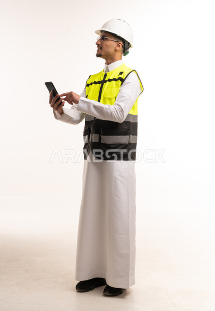 مهندس سعودي بزي السلامة يستخدم الهاتف الذكي