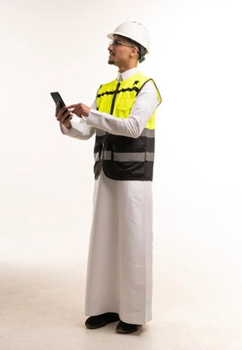 مهندس سعودي بزي السلامة يستخدم الهاتف الذكي