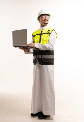 مهندس سعودي يحمل لاب توب بملابس السلامة